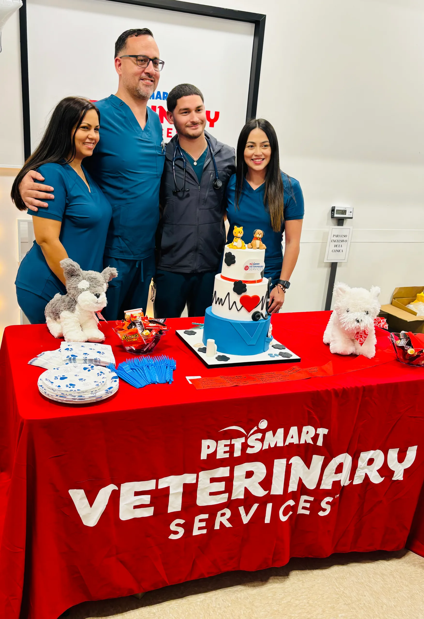 The team together standing behind the cake