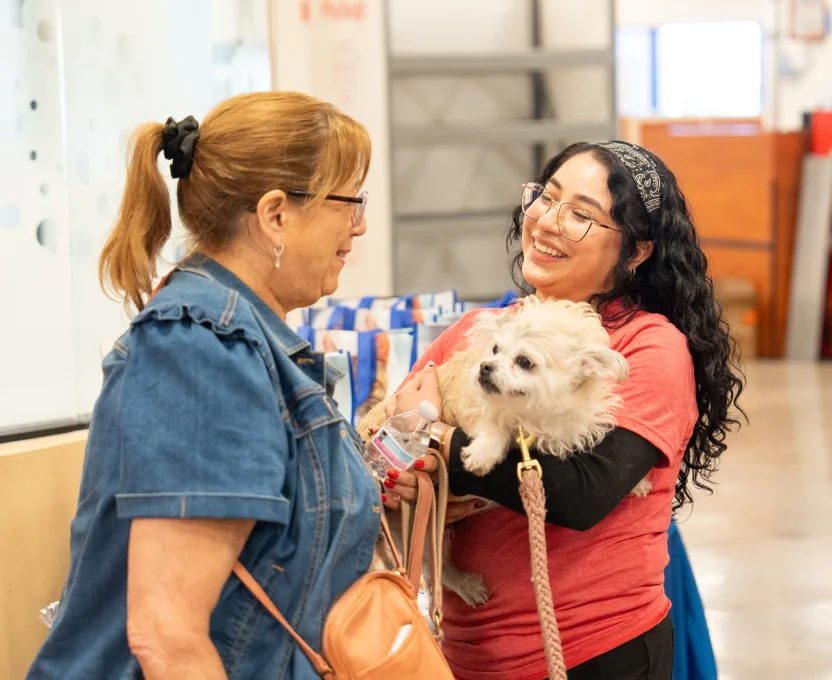 Vet and customer standing with dog in arms