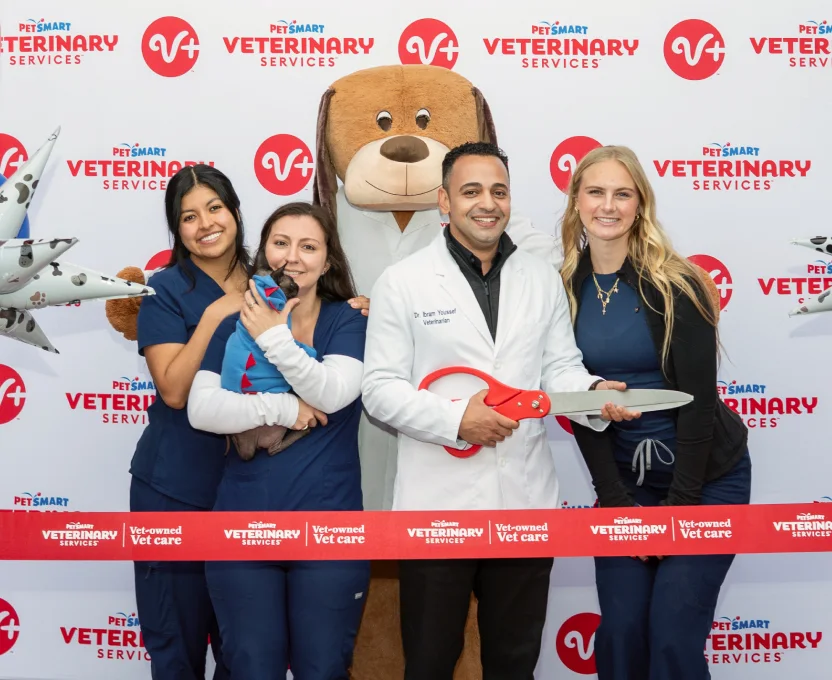 Team standing in front of PVS banner doing ribbon cutting