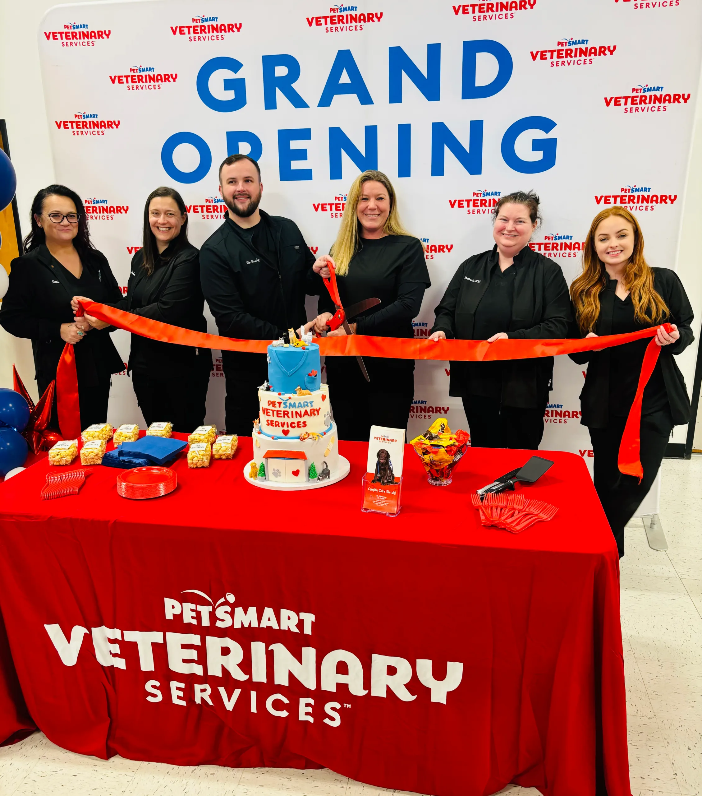 Team in front of grand opening banner