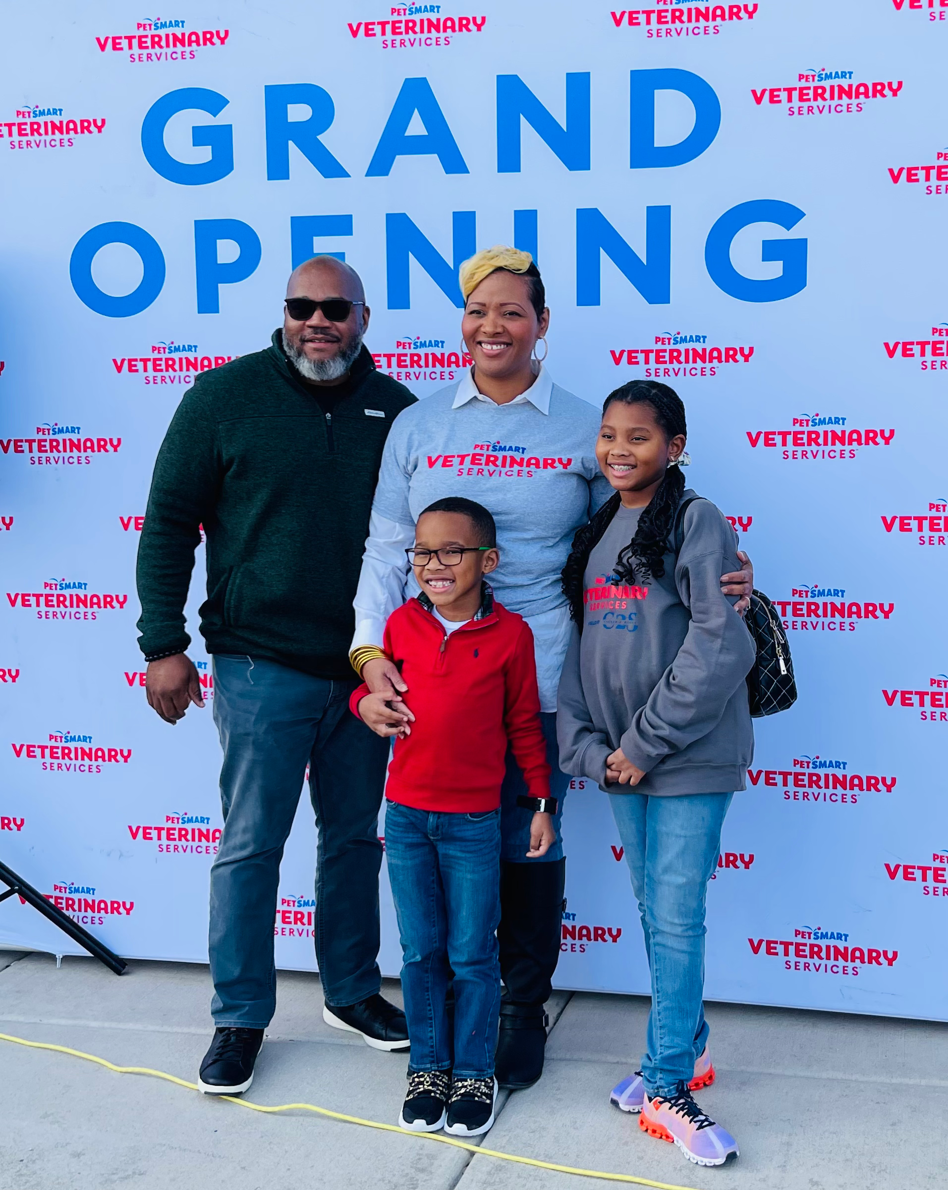 Standing with family in front of grand opening sign